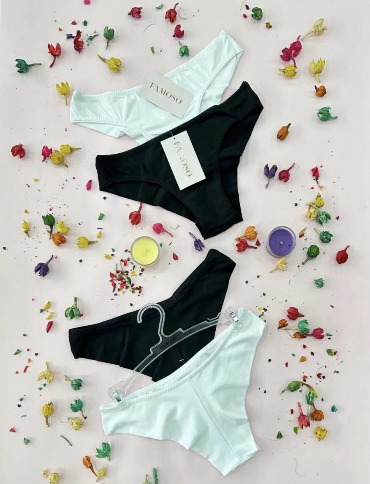 Three pairs of underwear on a light pink background with colorful flowers and candles.