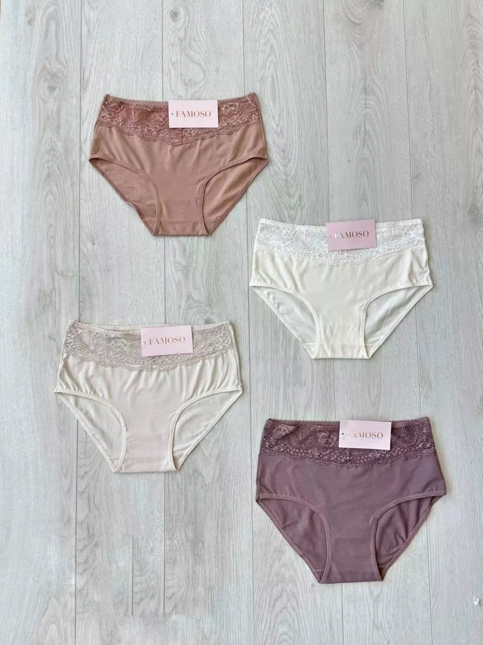 Four pairs of women's underwear in different colors on a wooden surface.