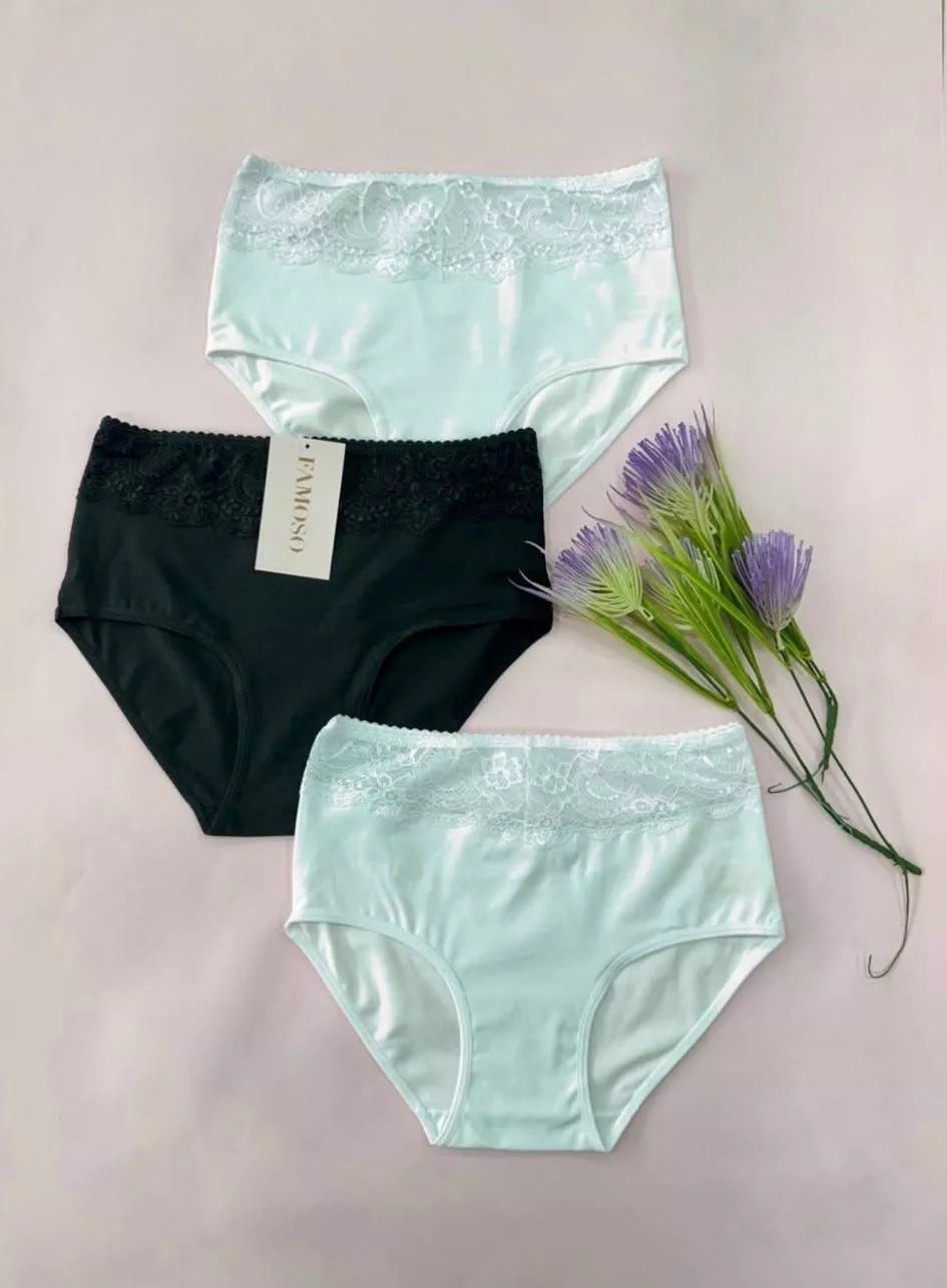 Three pairs of underwear in black and two shades of green on a light pink background with a tag and flowers.