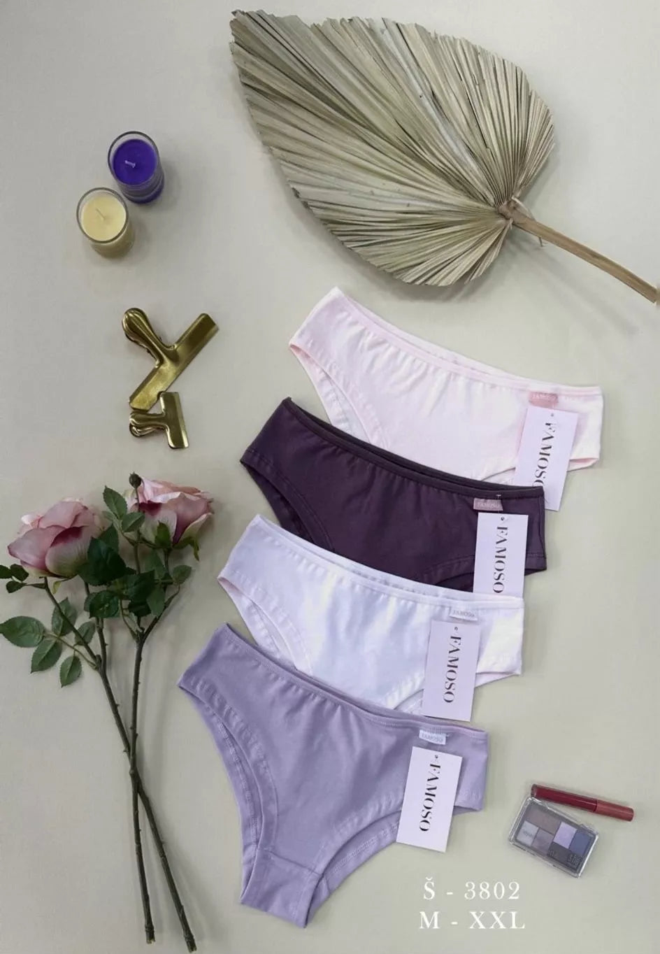 Set of women's underwear with visible brand name on a light surface with decorative elements.