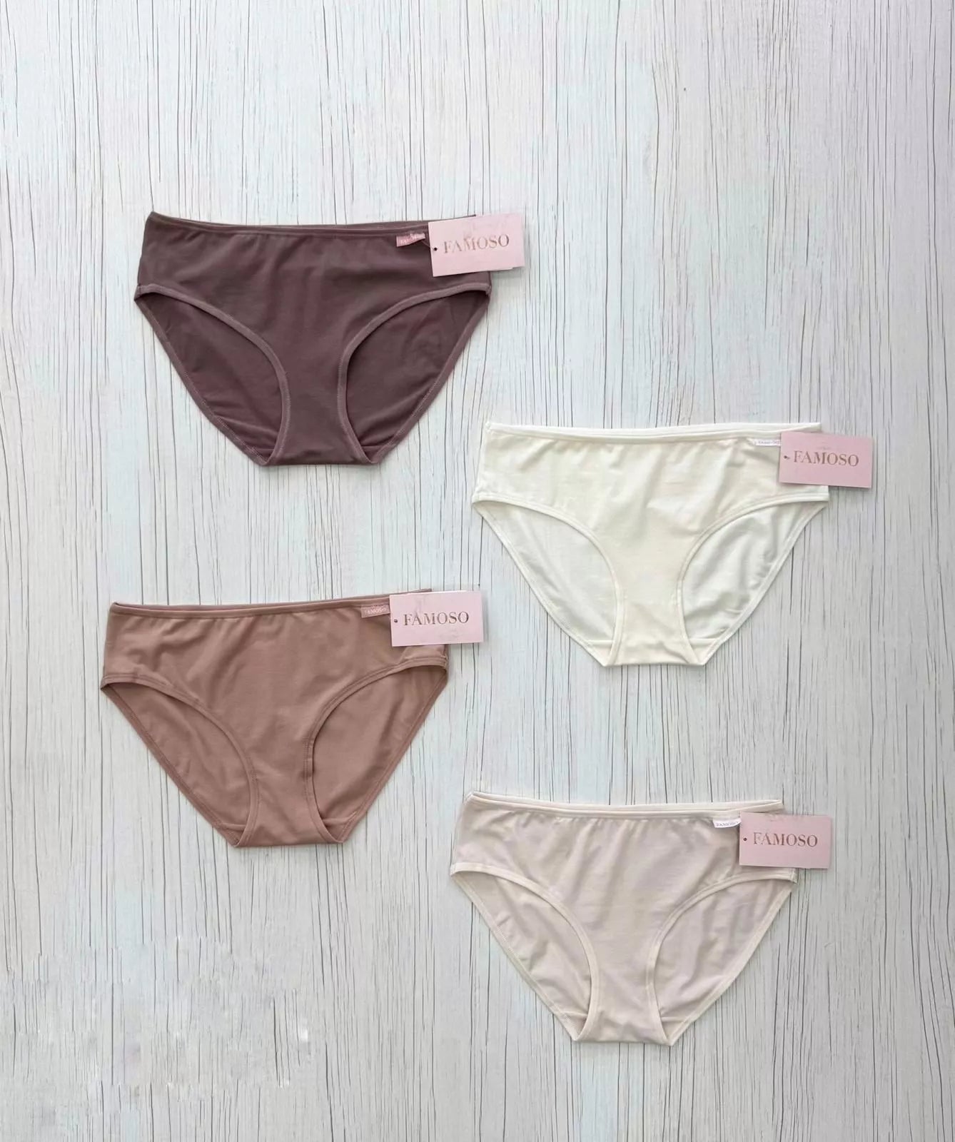 Four pairs of women's underwear in different colors on a light wooden surface with 'Calamuso' branding.