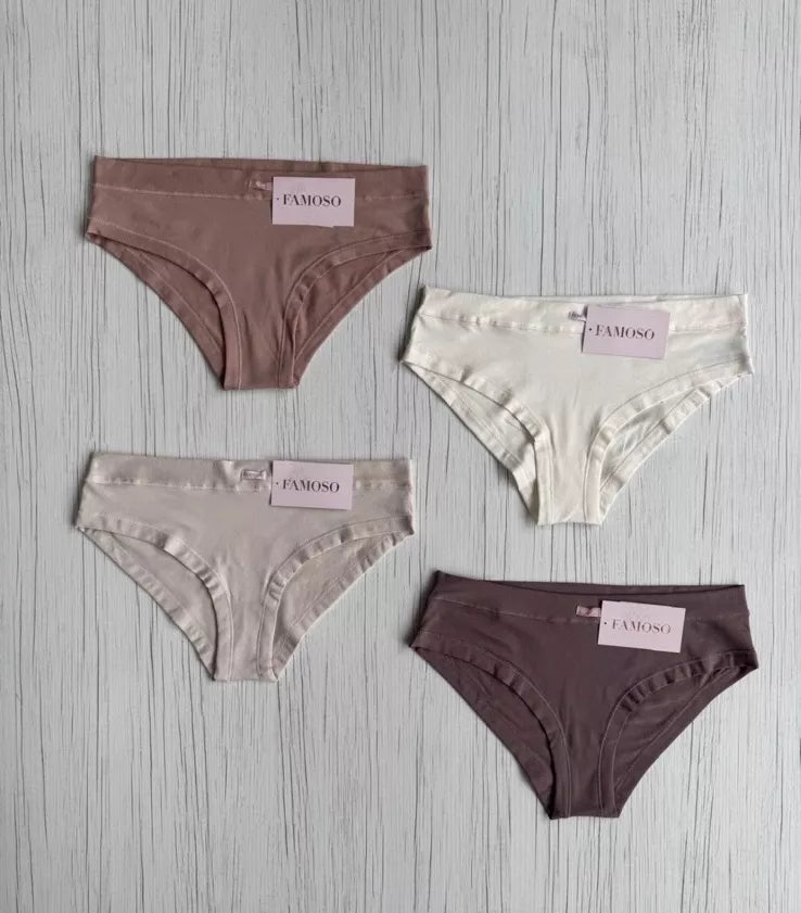 Four pairs of underwear in different colors on a gray wooden surface with 'Famoso' branding.