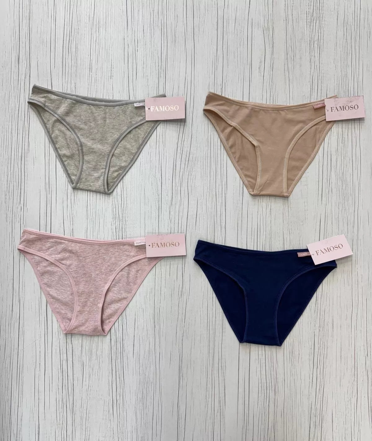 Four pairs of underwear in gray, beige, pink, and navy on a wooden surface with 'Famoso' branding.